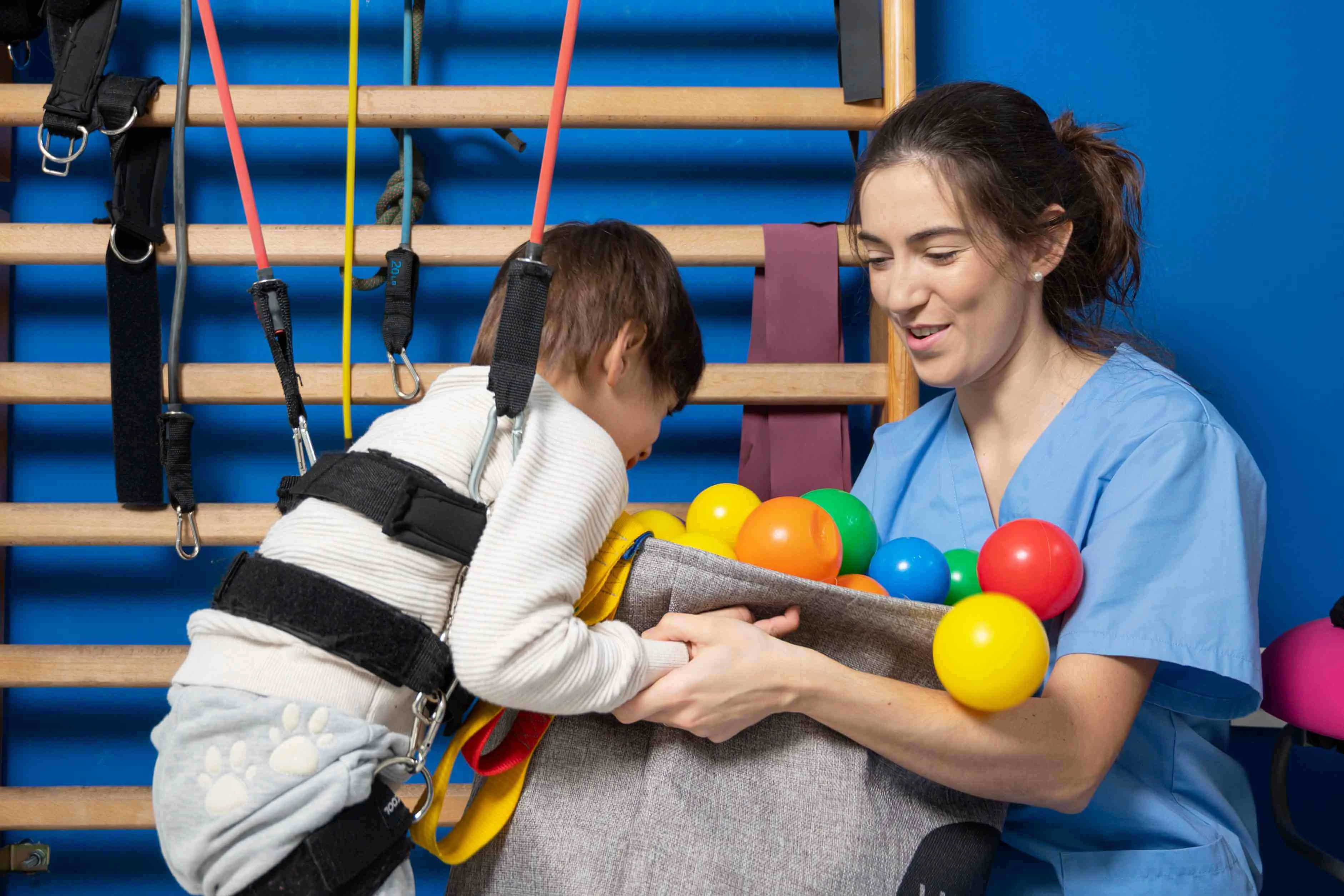 Lachende jongen met neurologische aandoening tijdens therapiesessie – Zorg op maat voor groei en levenskwaliteit.