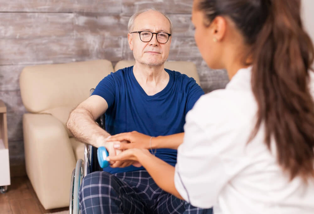 Oudere man met neurologische aandoening tijdens revalidatietherapie – Zorg op maat voor een waardig en zelfstandig leven.